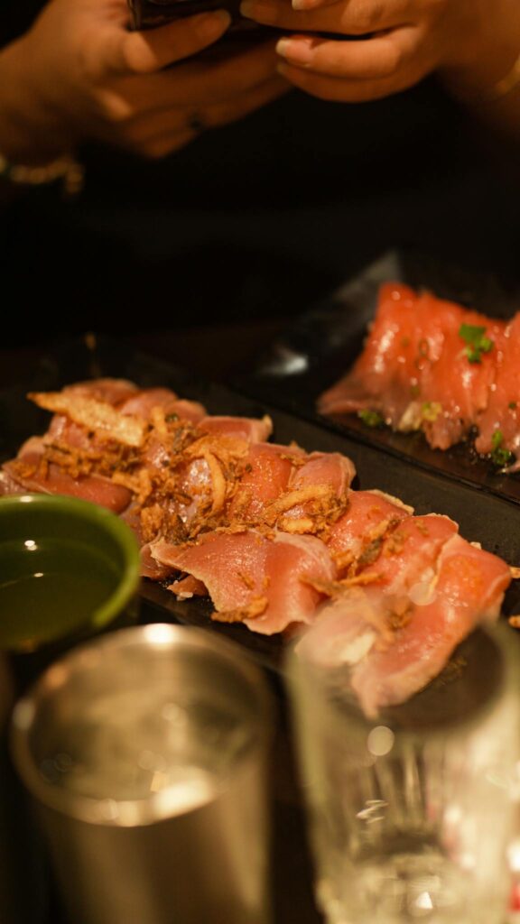 Appetizing raw meat slices on plate with a warm, cozy ambiance in a restaurant.